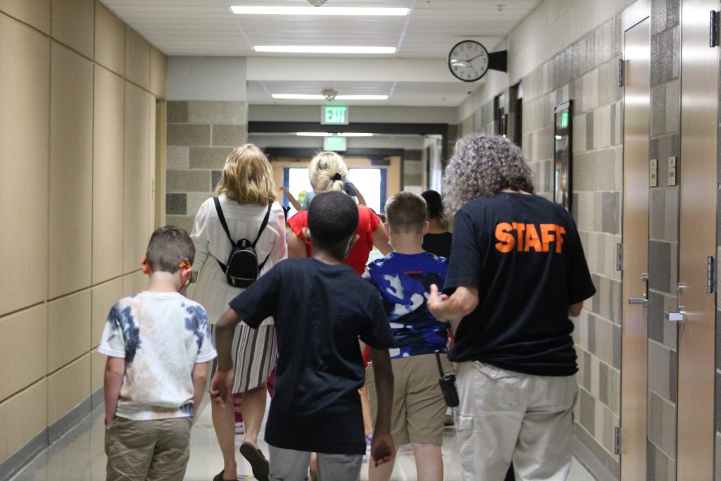 staff guiding students through a building